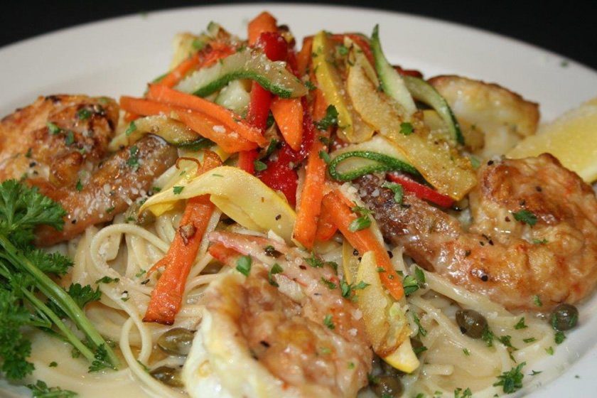 Shrimp and vegetable pasta finished with a lemon wedge