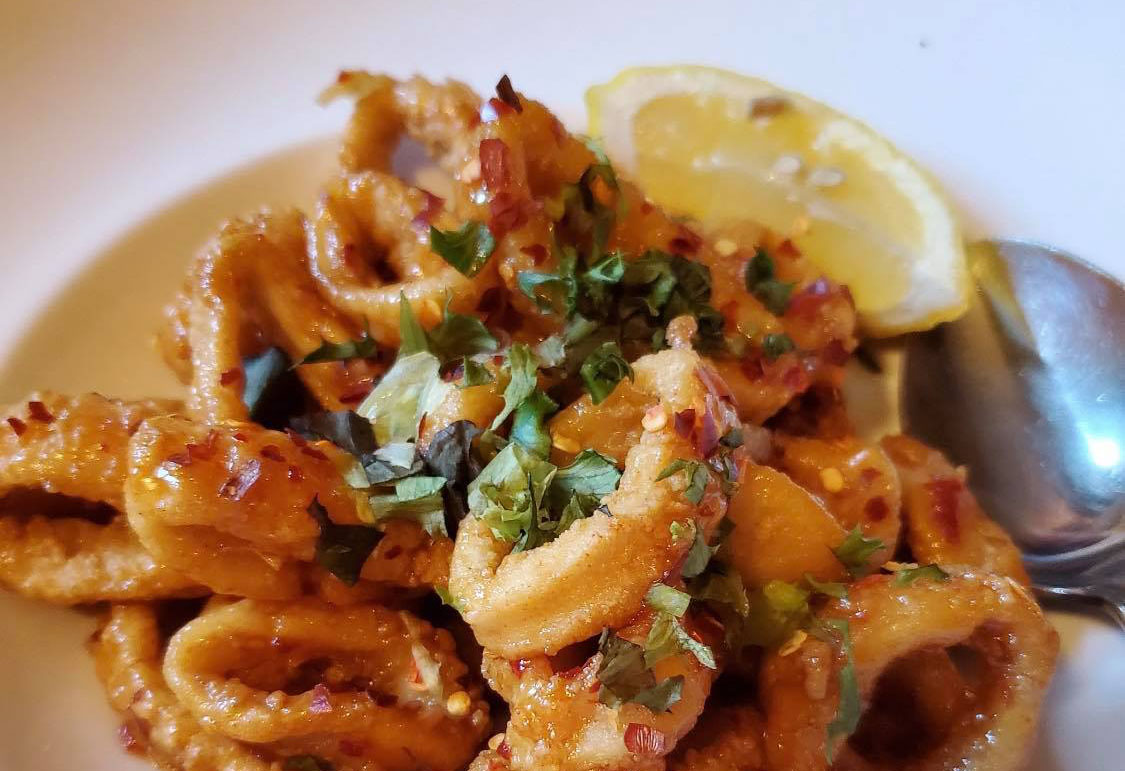 Fried calamari with herbs and a lemon wedge