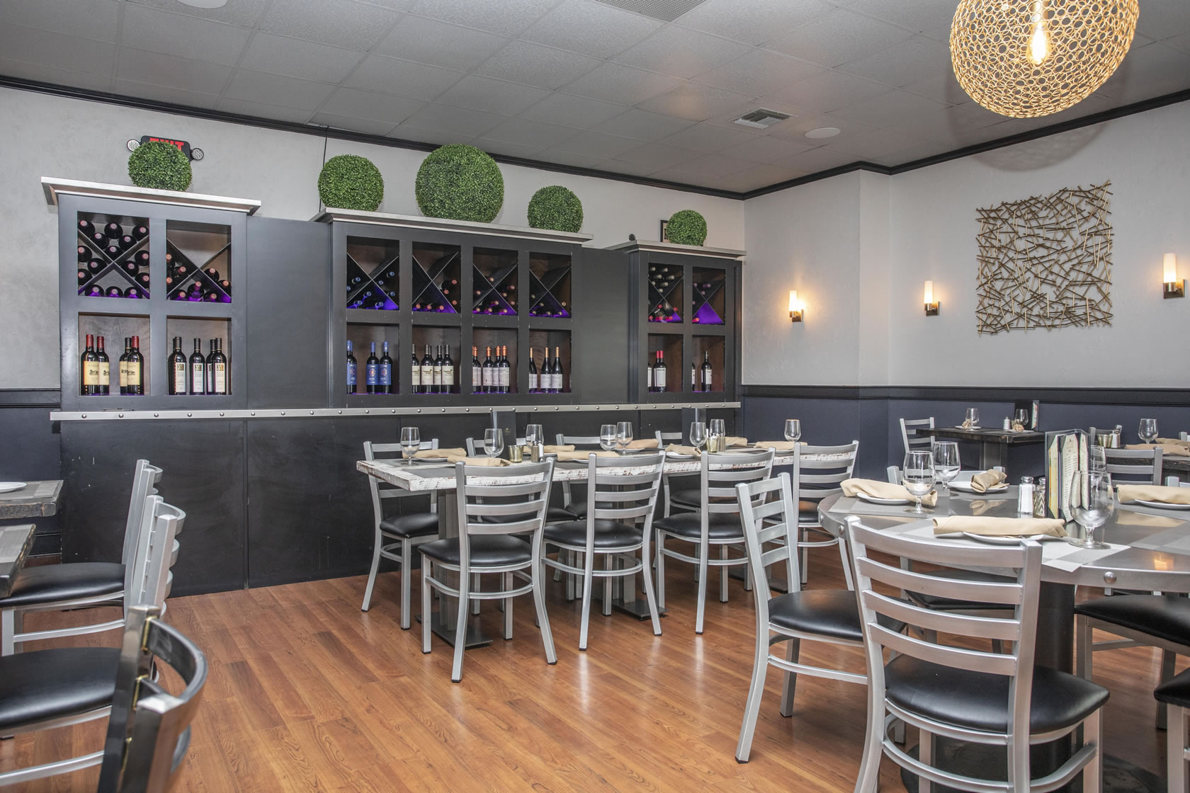 Modern dining area with a large wine rack and spherical lighting