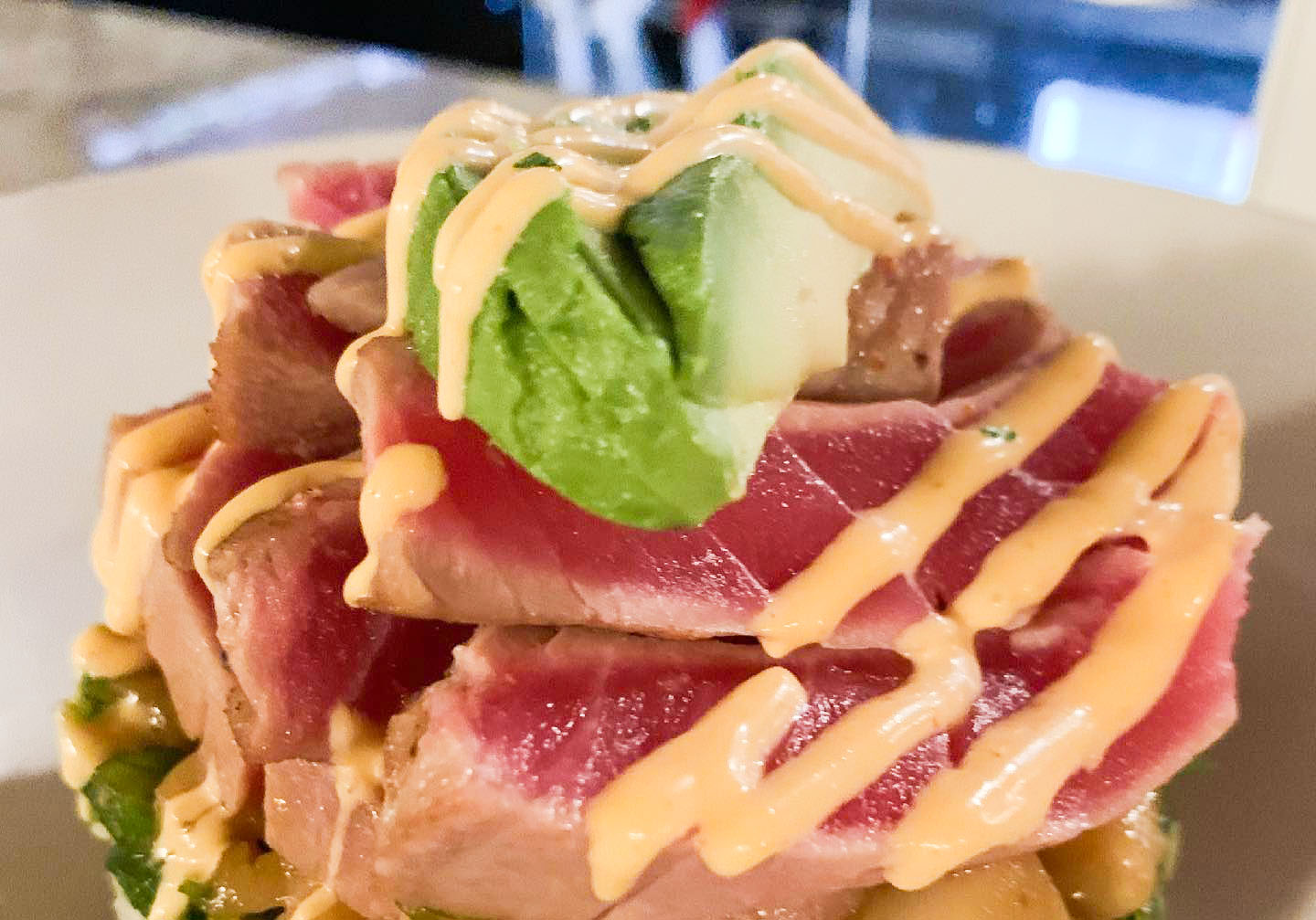 Seared tuna tower topped with avocado and spicy mayo