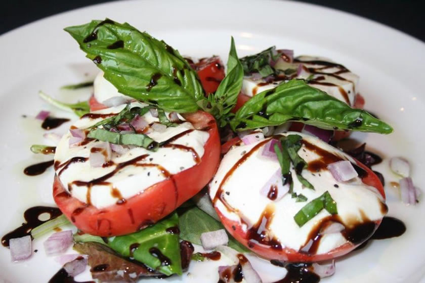 Mozzarella caprese with sliced tomato, basil and balsamic glaze