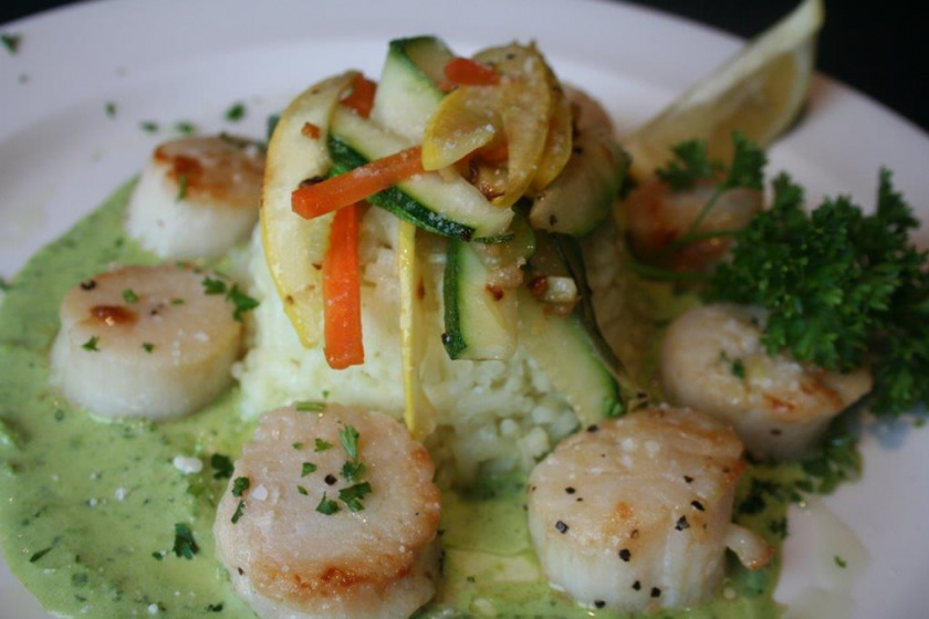 Pan seared scallops over risotto with vegetables