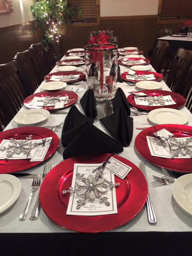 Long formal table set for a private event with red chargers