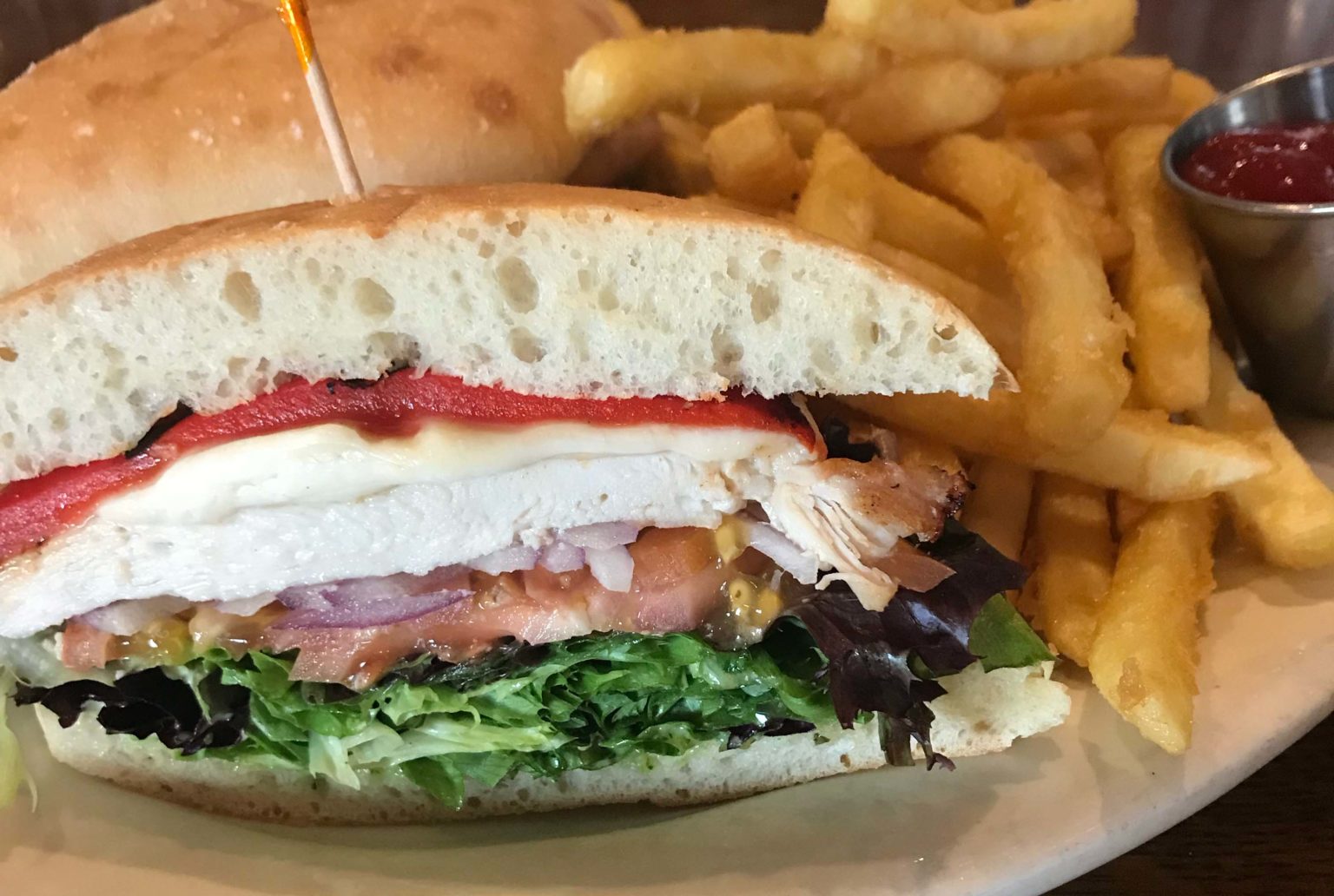 Grilled chicken sandwich with roasted red peppers and fries