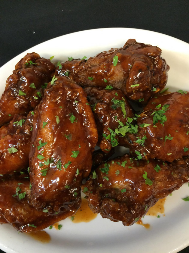 Chicken wings with a dark glaze and parsley